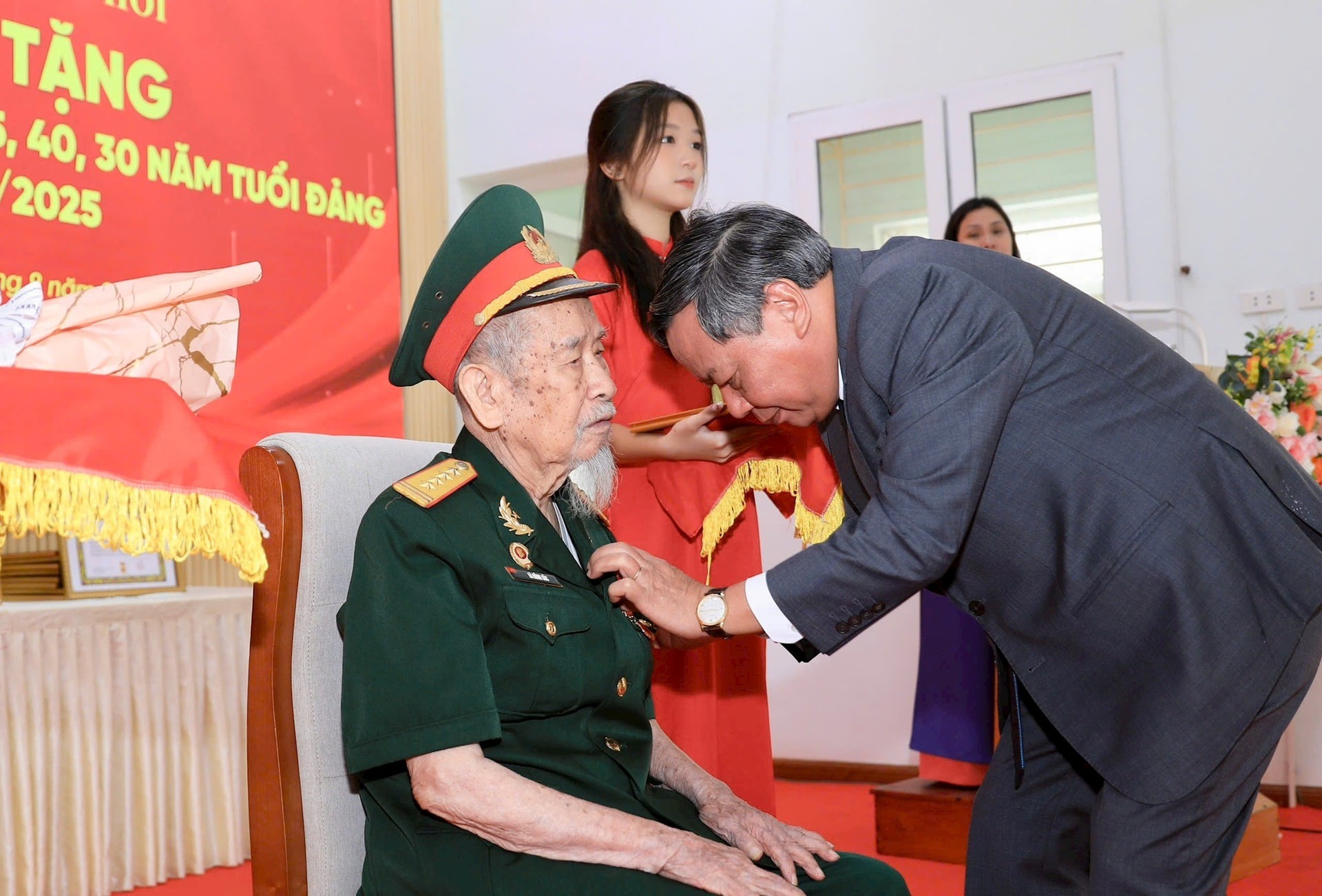 Phó Bí thư Thường trực Thành ủy Hà Nội Nguyễn Văn Phong gắn Huy hiệu 80 năm tuổi Đảng tặng đồng chí Lã Hồng Sắc (Lã Tiến Sắc). Ảnh: Quang Thái.