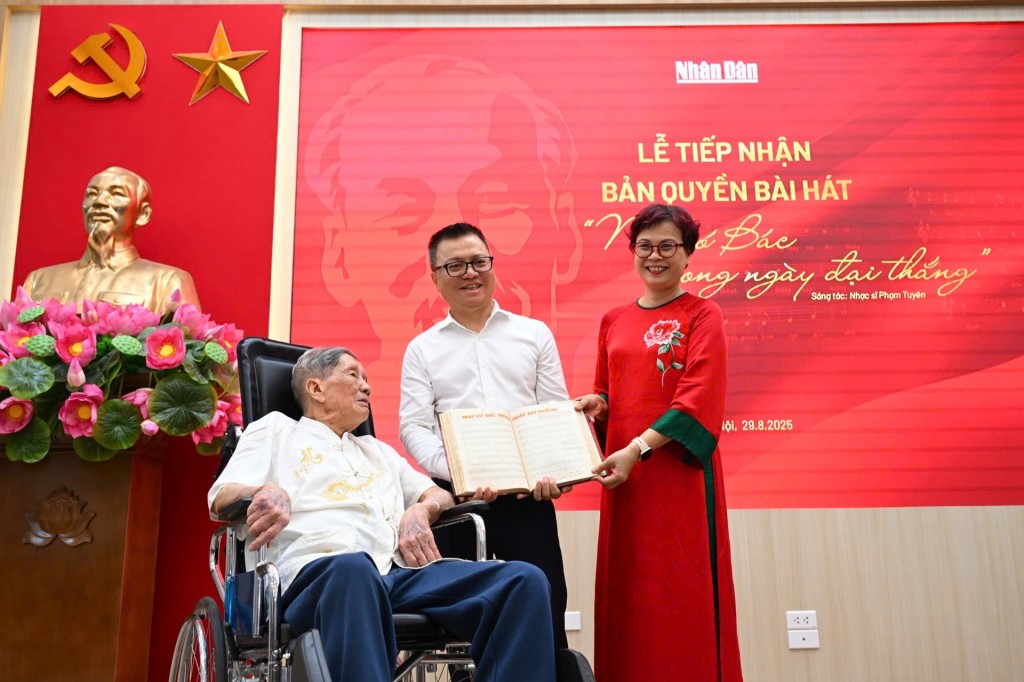  Lê Quốc Minh nhận cuốn sổ ghi bài hát của nhạc sĩ Phạm Tuyên từ gia đình nhạc sĩ (Ảnh: Thành Đạt)