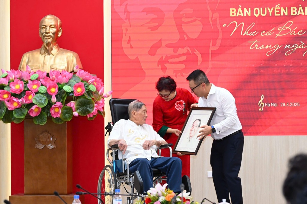 Ông Lê Quốc Minh trao tặng nhạc sĩ Phạm Tuyên bức ảnh chân dung do họa sĩ Đỗ Hoàng Tường vẽ (Ảnh: Thành Đạt)