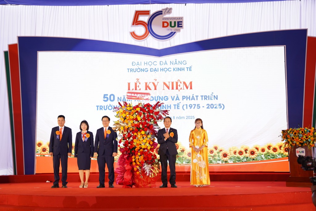 Phó Bí thư Thường trực Thành ủy Đà Nẵng Nguyễn Đình Vĩnh tặng hoa chúc mừng lãnh đạo nhà trường 