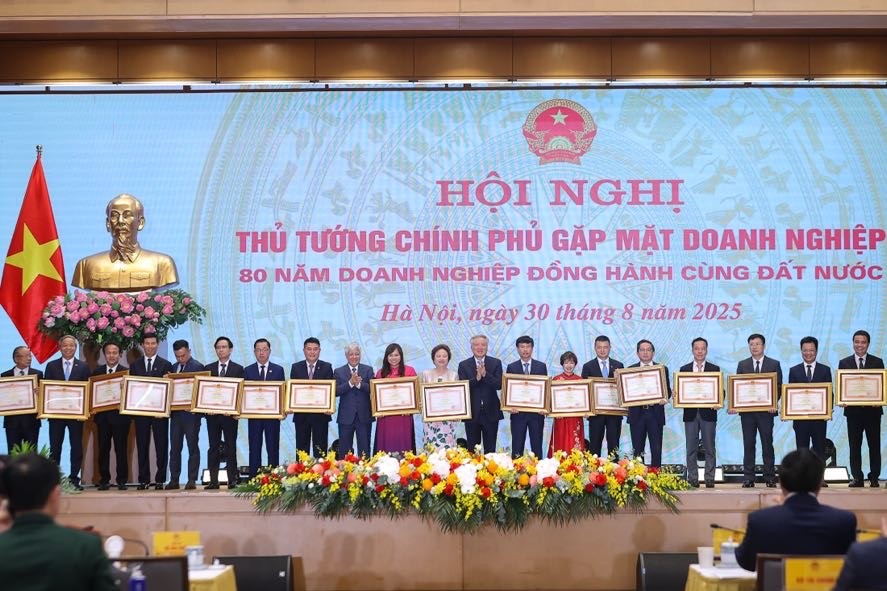 Chủ tịch Ủy ban Trung ương MTTQ Việt Nam Đỗ Văn Chiến và Phó Thủ tướng Thường trực Chính phủ Nguyễn Hoà Bình trao Bằng khen của Thủ tướng Chính phủ tặng 18 doanh nghiệp tiêu biểu - Ảnh: VGP/Nhật Bắc