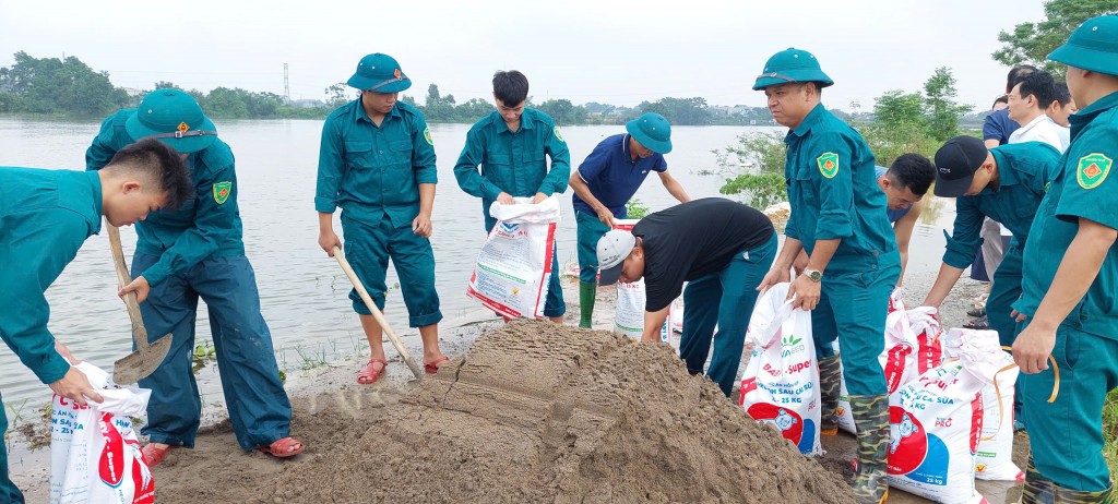 Lực lượng dân quân tự vệ, công chức phòng Kinh tế xã Phú Nghĩa tham gia đắp bao tải cát chống tràn đê.