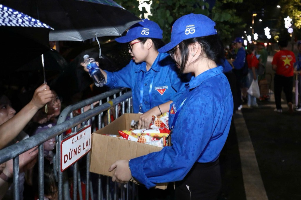 Tình nguyện viên trao đồ ăn nhẹ đến người dân 