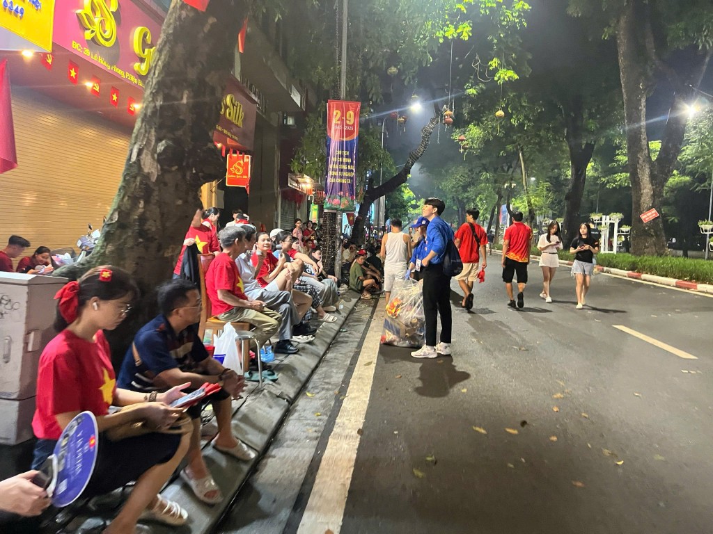 Người dân ngồi chờ qua đêm dọc phố trung tâm Hà Nội để đón xem lễ diễu binh, diễu hành sáng 2/9, trong khi đoàn viên thanh niên tình nguyện cần mẫn thu gom rác, giữ gìn vệ sinh môi trường, góp phần tạo hình ảnh Thủ đô văn minh trong ngày lễ lớn.