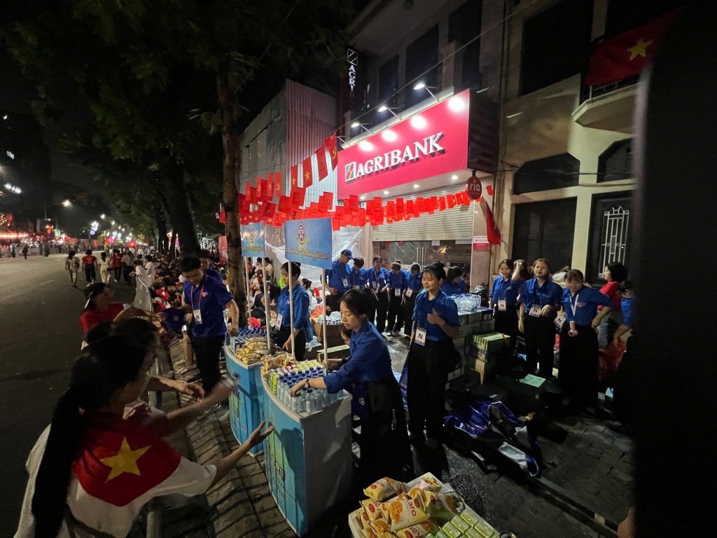 Các đoàn viên, thanh niên tình nguyện Hà Nội phát nước uống, bánh kẹo miễn phí cho người dân và du khách xuyên đêm 1/9, tiếp sức cho hàng vạn người chờ xem lễ diễu binh, diễu hành kỷ niệm 80 năm Quốc khánh.