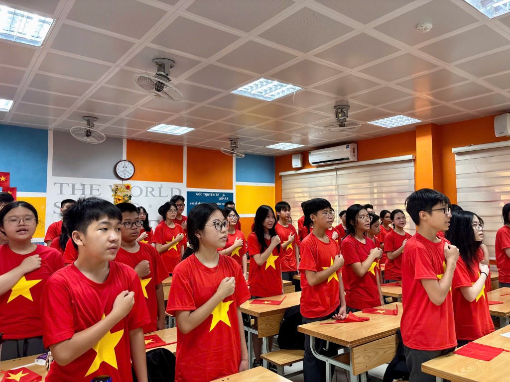 Học sinh trong lớp đồng loạt đặt tay lên ngực, cất cao tiếng hát Quốc ca trong ngày khai giảng.