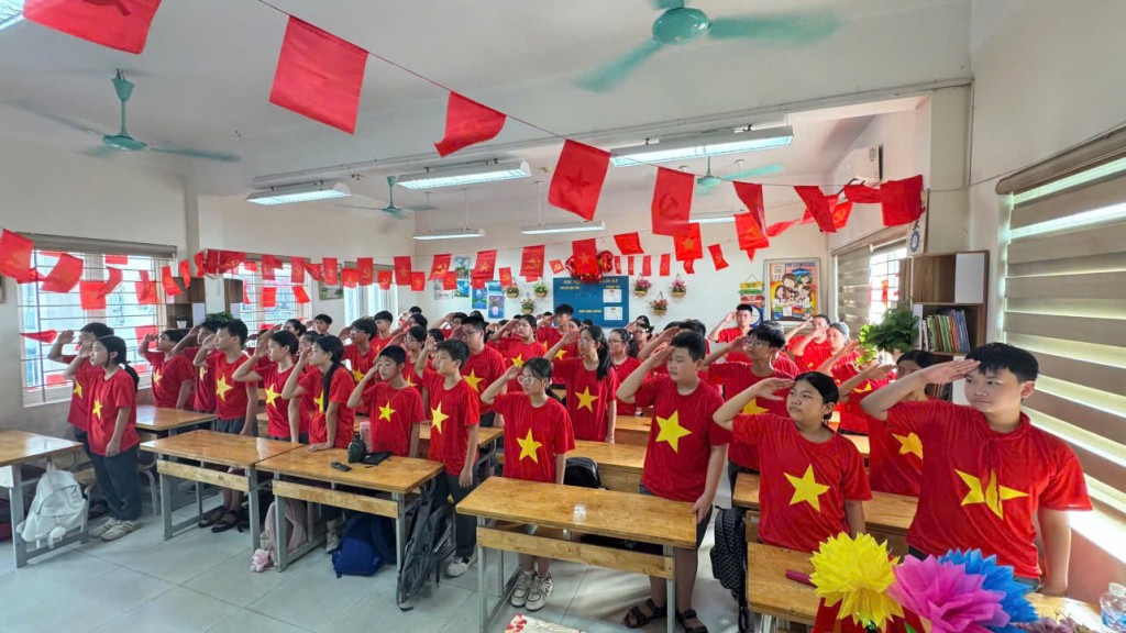 Khoảnh khắc nghiêm trang khi các em học sinh chào cờ trong không khí rực đỏ sắc cờ Tổ quốc.n ngực, cất cao tiếng hát Quốc ca trong ngày khai giảng