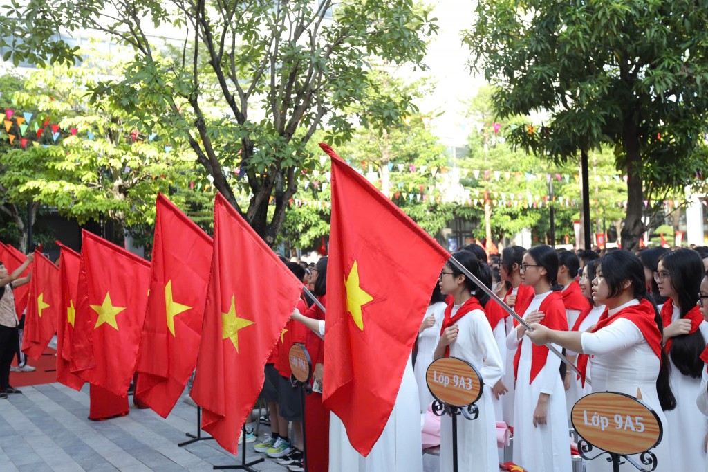 Lá cờ đỏ sao vàng tung bay trên tay học trò, tượng trưng cho niềm tin, khát vọng và trách nhiệm thế hệ trẻ.