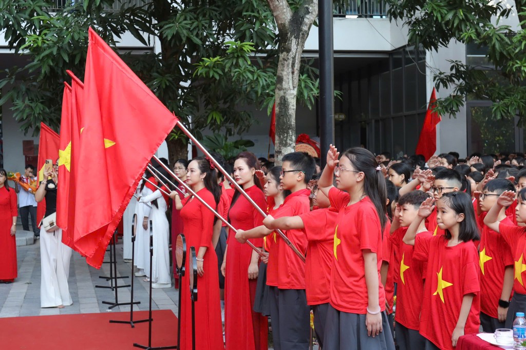 Lá cờ đỏ sao vàng tung bay trên tay học trò, tượng trưng cho niềm tin, khát vọng và trách nhiệm thế hệ trẻ.