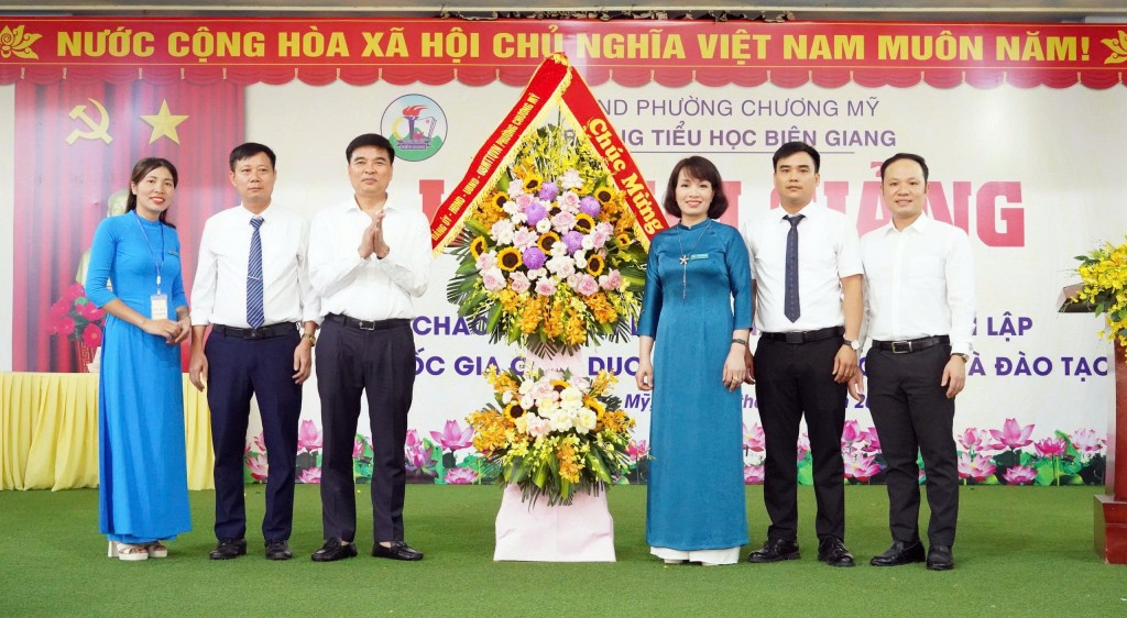 Đồng chí Trịnh Duy Oai, chủ tịch UBND phường Chương Mỹ tặng hoa, chúc mừng năm học mới trường Tiểu học Biên Giang