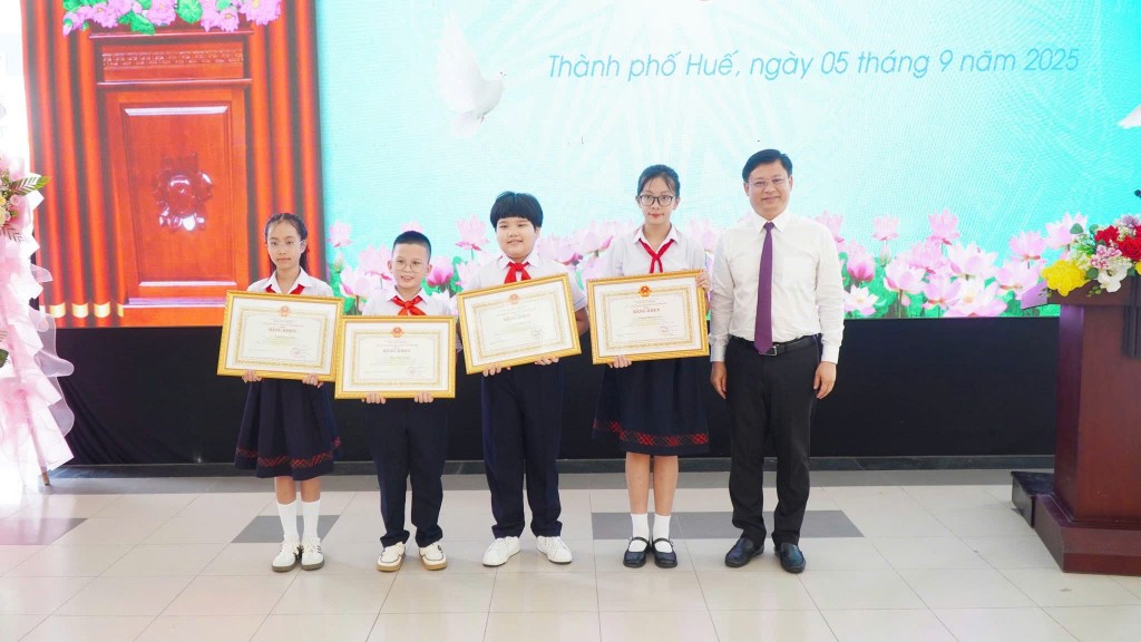 Phó Chủ tịch Thường trực UBND thành phố Huế Nguyễn Thanh Bình trao Bằng khen của Chủ tịch UBND thành phố cho các học sinh đạt thành tích xuất sắc