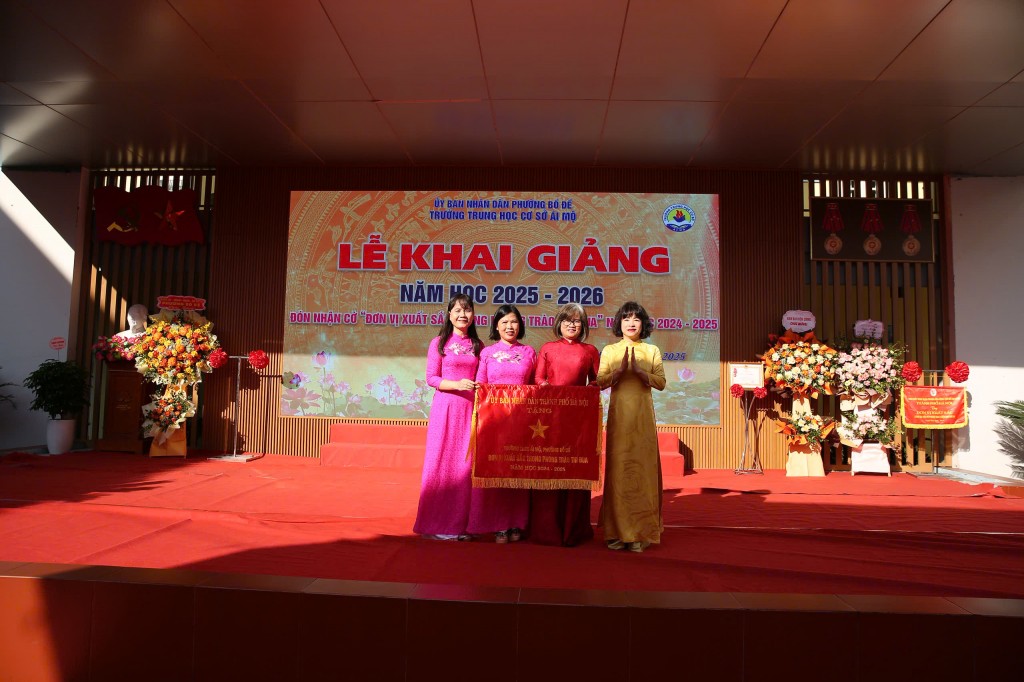 Đồng chí Vũ Thị Thành - Bí thư Đảng ủy, Chủ tịch HĐND phường Bồ Đề trao cờ thi đua cho trường THCS Ái Mộ A
