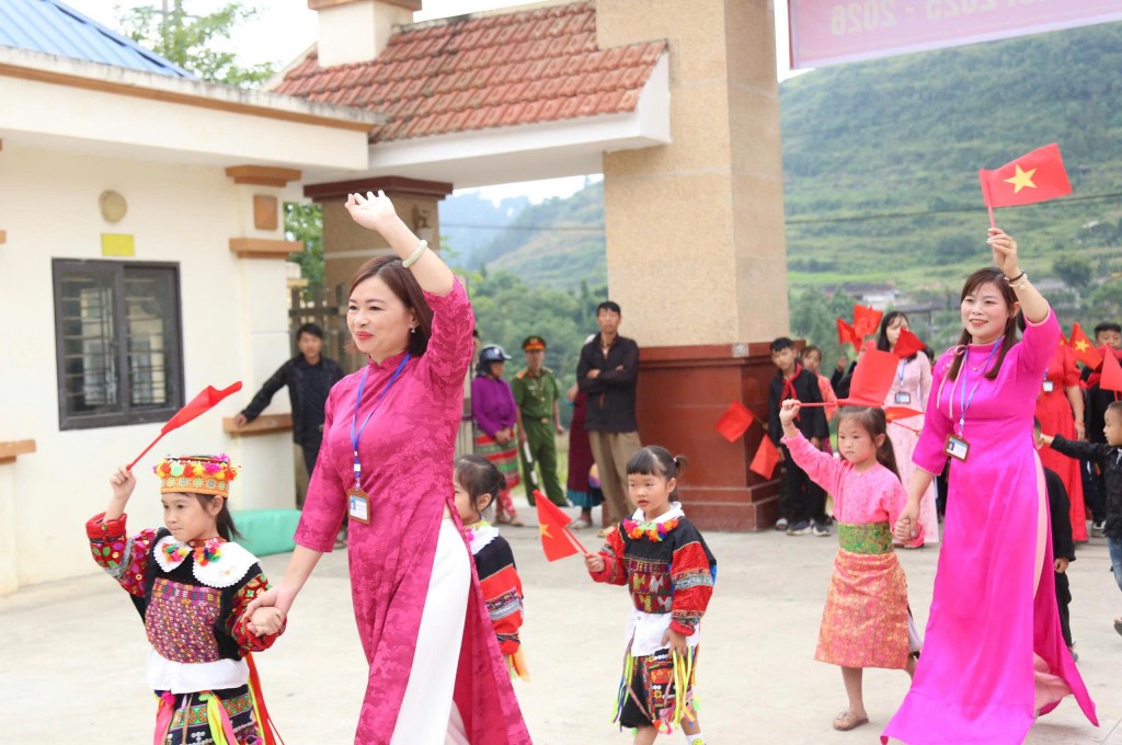 Phía sau bộ váy thổ cẩm rực rỡ là đôi mắt long lanh háo hức. Ngày khai trường, ánh nhìn ấy chan chứa niềm vui gặp lại thầy cô, bè bạn sau kỳ nghỉ hè.