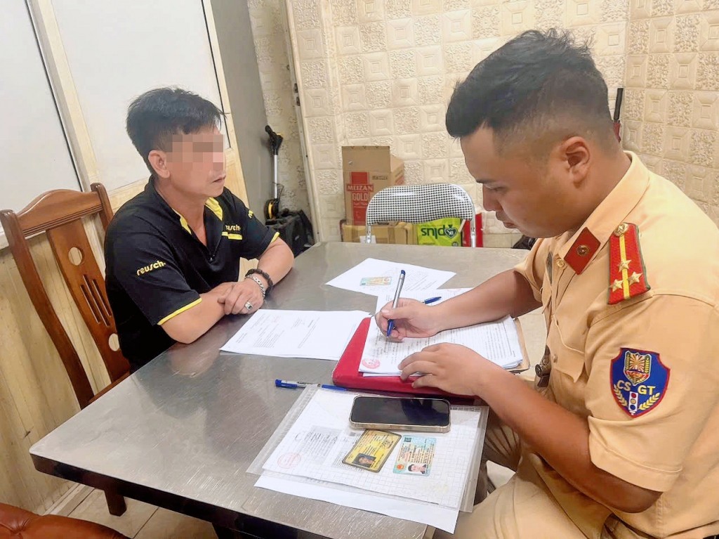 Cảnh sát giao thông lập biên bản, xử lý tài xế điều khiển xe tải để dầu tràn ra đường