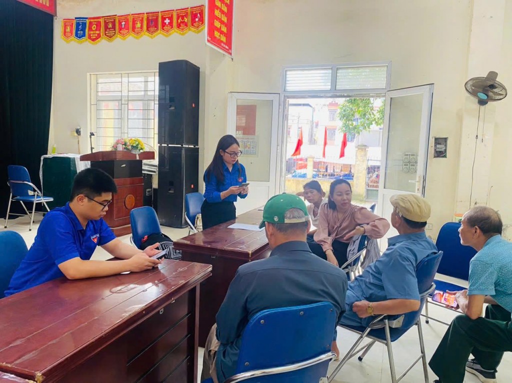 Các bạn đoàn viên thanh niên hướng dẫn người dân ứng dụng công nghệ số trên điện thoại thông minh