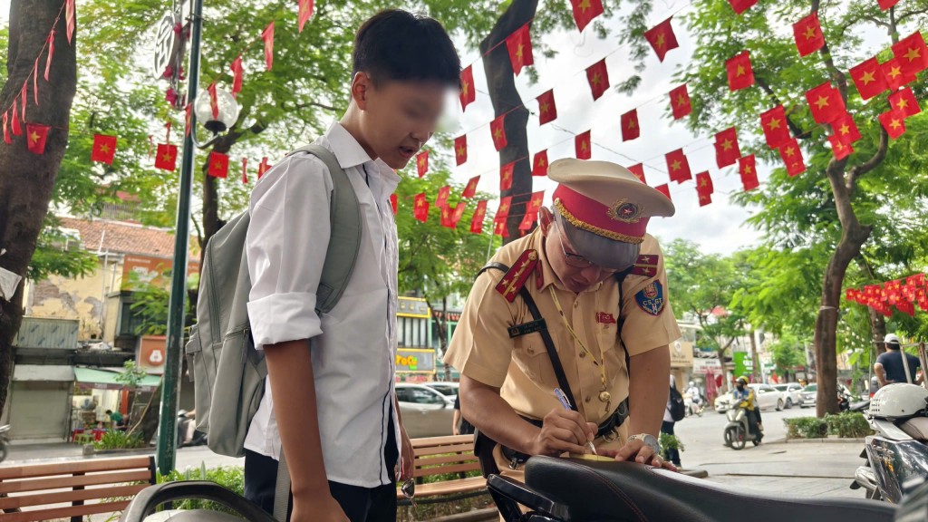 Một học sinh ký cam kết, ghi rõ nội dung vi phạm giao thông dưới sự hướng dẫn của lực lượng chức năng. Một học sinh ký cam kết, ghi rõ nội dung vi phạm giao thông dưới sự hướng dẫn của lực lượng chức năng.
