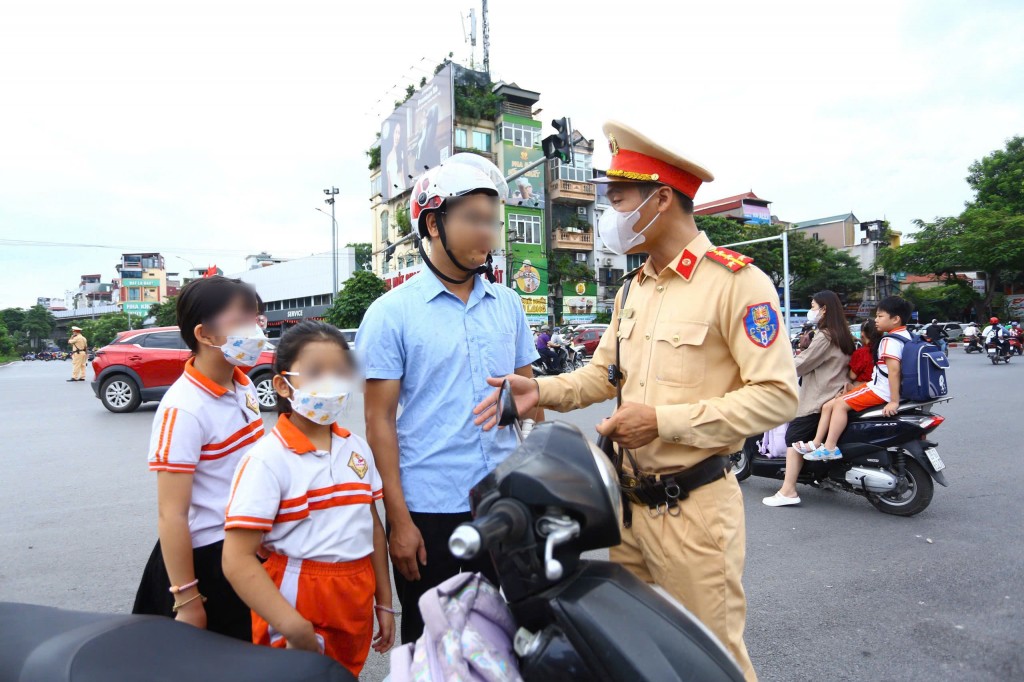 Cảnh sát giao thông trao đổi với phụ huynh và học sinh vi phạm ngay tại nút giao thông đông đúc ở trung tâm thành phố. Cảnh sát giao thông trao đổi với phụ huynh và học sinh vi phạm ngay tại nút giao thông đông đúc ở trung tâm thành phố.