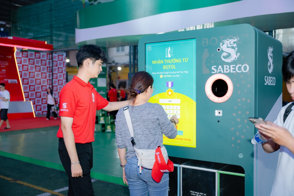 Người tham dự khám phá và tương tác với máy tái chế bao bì 