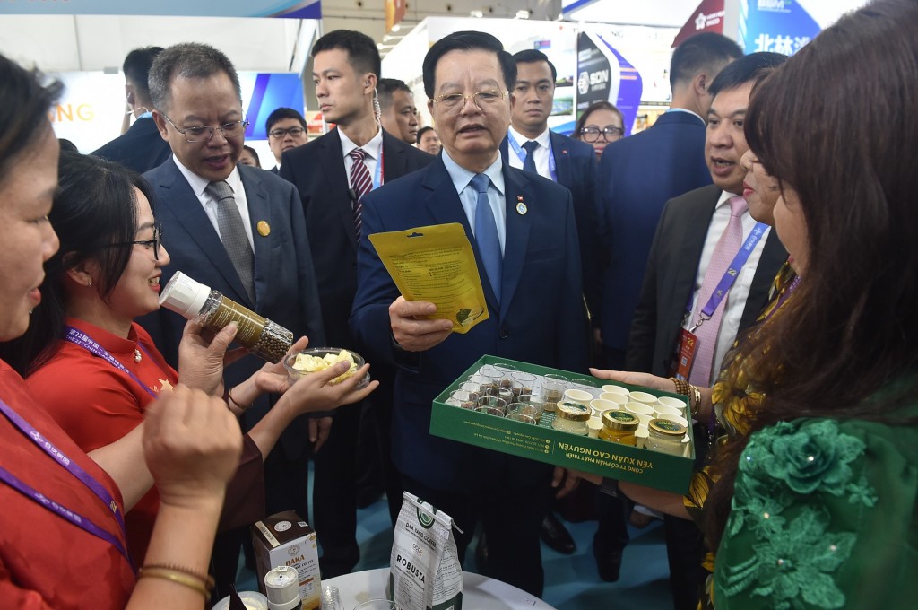 Phó Thủ tướng nghe giới thiệu về các sản phẩm của Việt Nam trưng bày tại Hội chợ - Ảnh: VGP/Giang Thanh