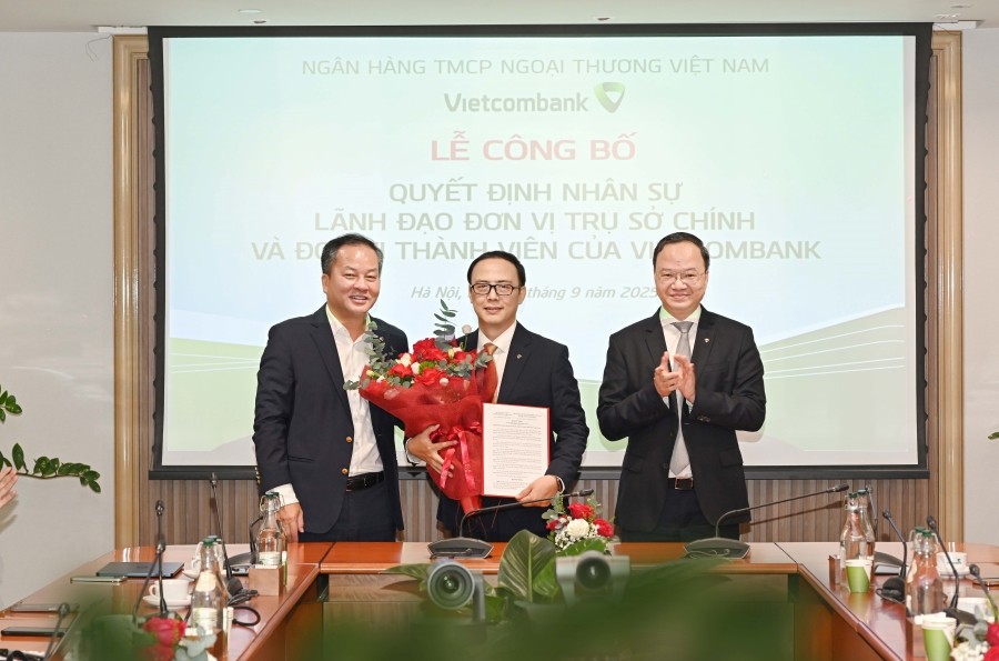 Ông Lê Quang Vinh - Thành viên Hội đồng quản trị, Tổng Giám đốc Vietcombank (bên phải) và ông Nguyễn Việt Cường - Phó Tổng Giám đốc Vietcombank (bên trái) trao quyết định và tặng hoa chúc mừng ông Nguyễn Ngọc Quang - tân Trưởng Văn phòng đại diện Vietcomb