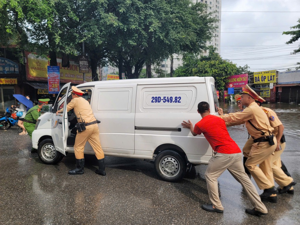 Lực lượng CSGT hỗ trợ người dân di chuyển phương tiện chết máy.