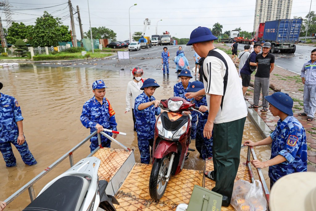 Lực lượng Cảnh sát biển hỗ trợ người dân vượt qua khu vực ngập sâu ở đường 70 (đoạn qua phường Tây Mỗ, Xuân Phương)