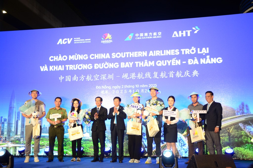 Lãnh đạo ngành du lịch Đà Nẵng và Công ty CP Đầu tư Khai thác Nhà ga Quốc tế Đà Nẵng tặng hoa và quà cho các hành khách đầu tiên (Ảnh Đ.Minh)