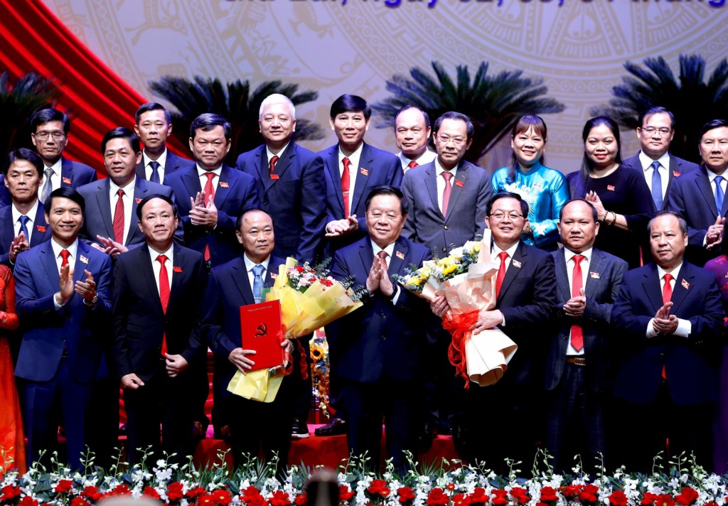 Trưởng Ban Tuyên giáo và Dân vận Trung ương Nguyễn Trọng Nghĩa tặng hoa chúc mừng tân Bí thư Tỉnh uỷ Gia Lai (bên trái) và ông Hồ Quốc Dũng (bên phải).