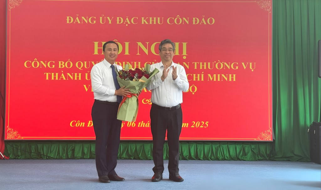 Phó Bí thư Thành ủy, Chủ tịch Ủy ban MTTQ Việt Nam TP Hồ Chí Minh Nguyễn Phước Lộc tặng hoa chúc mừng đồng chí Lê Hoàng Hải nhận nhiệm vụ Bí thư Đảng ủy đặc khu Côn Đảo. Ảnh: