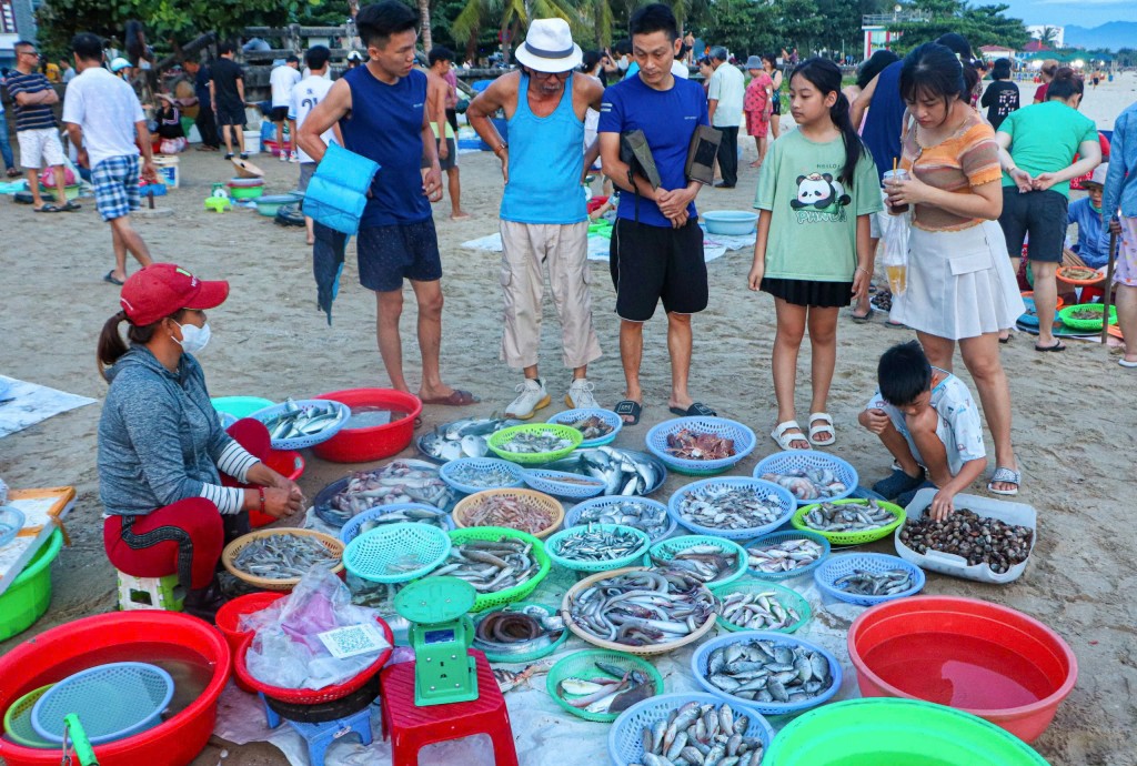 Ngoài buôn bán hải sản, chợ cá Mân Thái còn là địa điểm hút du khách ghé chân khi dạo, tắm biển sáng tại nơi đây (Ảnh Đ.Minh)