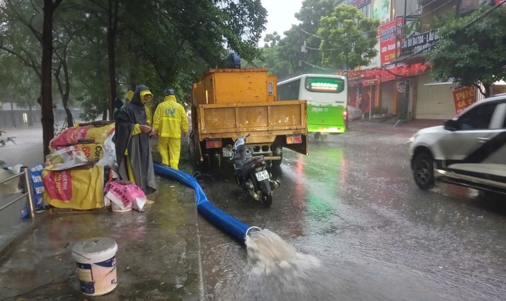 Sử dụng máy bơm thoát nước trên phố Thái Hà. Ảnh: Ngọc Uyên