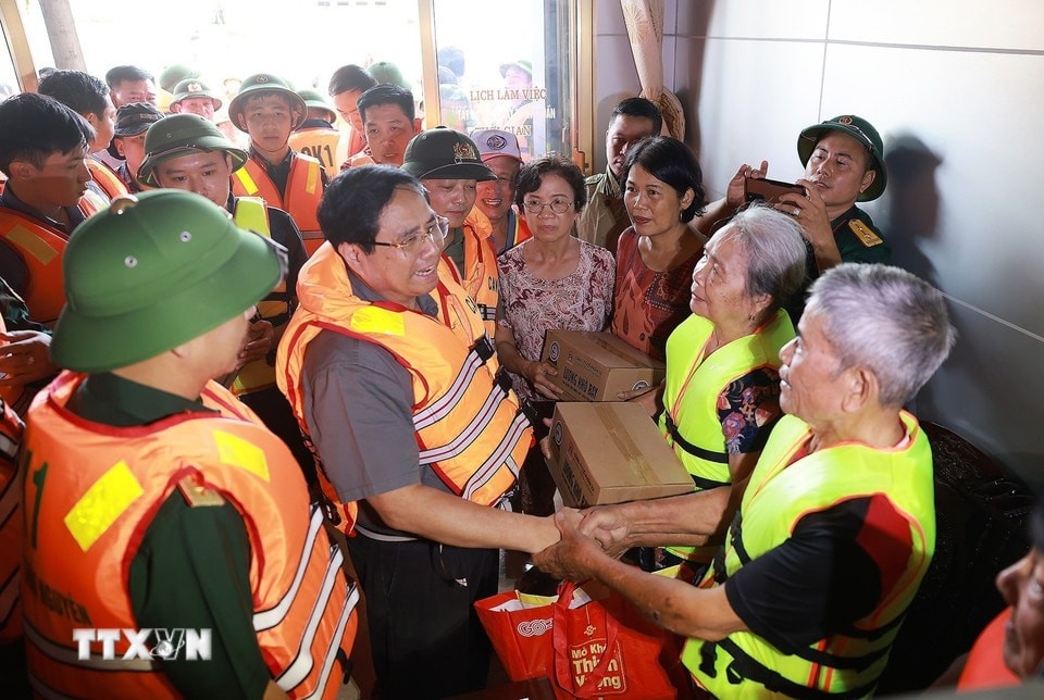 Thủ tướng Phạm Minh Chính động viên nhân dân khu vực ngập lụt tại Thái Nguyên. (Ảnh: Dương Giang/TTXVN)