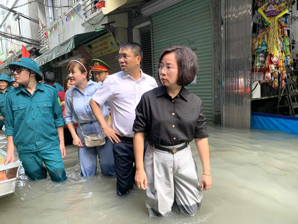 Phó Chủ tịch Thường trực Ủy ban Mặt trận Tổ quốc Việt Nam TP Hà Nội Bùi Huyền Mai cùng đoàn công tác lội nước đi thăm các hộ dân 