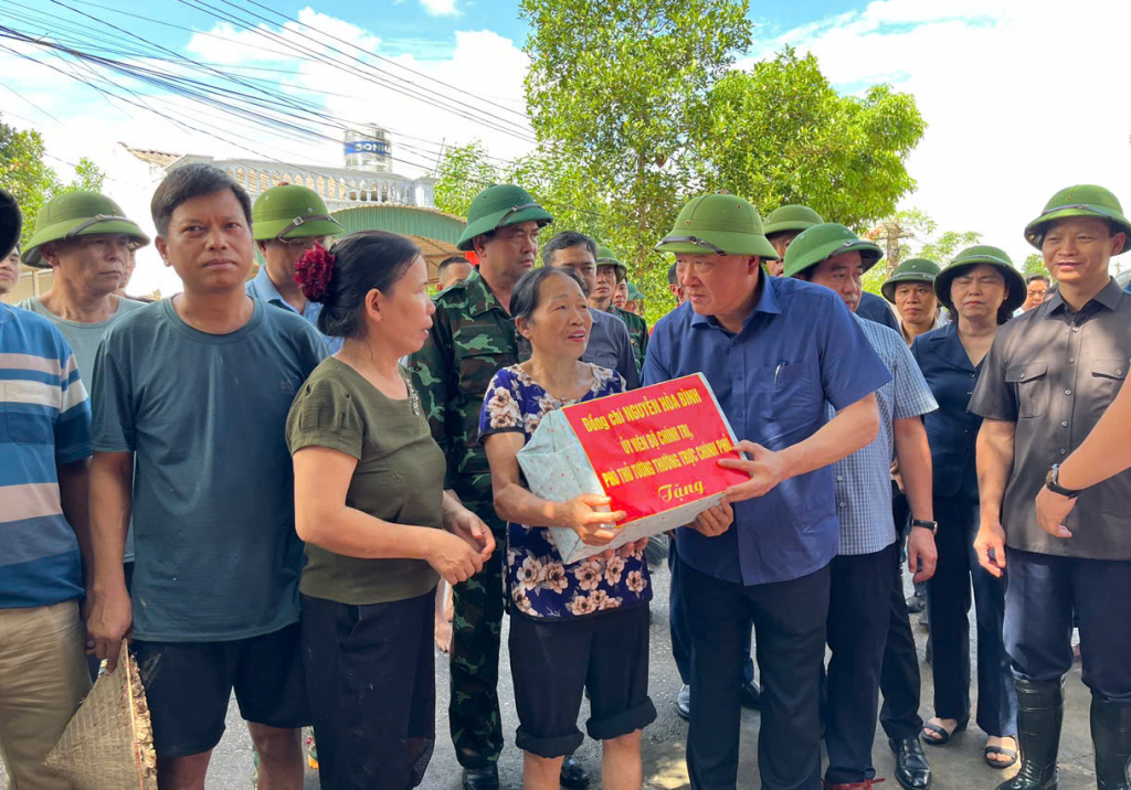 Phó Thủ tướng Thường trực Chính phủ Nguyễn Hoà Bình tặng quà cho người dân vùng lũ lụt xã Yên Thế - Ảnh: VGP/Nguyễn Hoàng