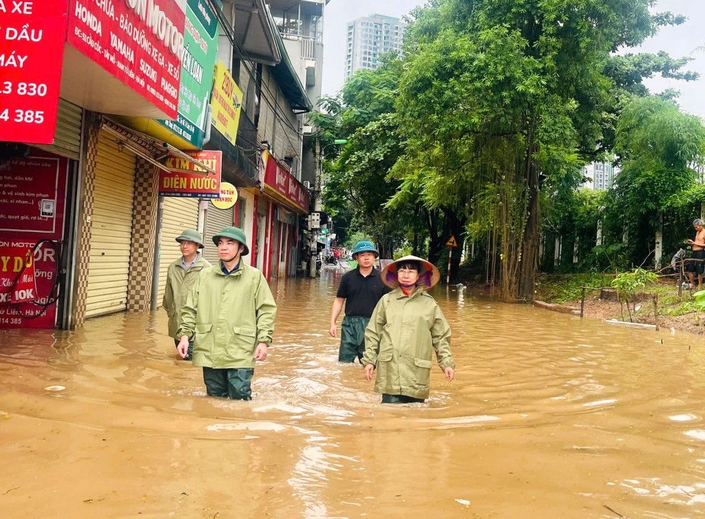 Các đồng chí lãnh đạo phường Tây Mỗ lội nước đi thăm hỏi, động viên các hộ dân và kiểm tra công tác ứng phó mưa bão