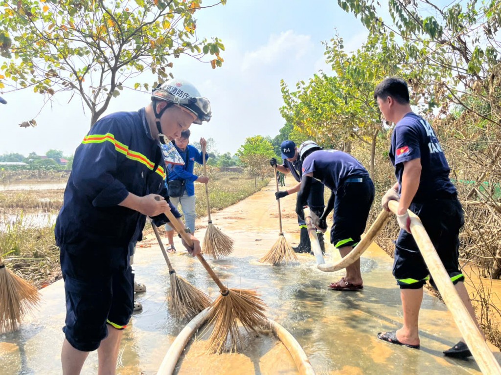 Cán bộ, chiến sĩ Cảnh sát PCCC và CNCH dùng vòi áp lực cao dọn bùn đất sau lũ lụt