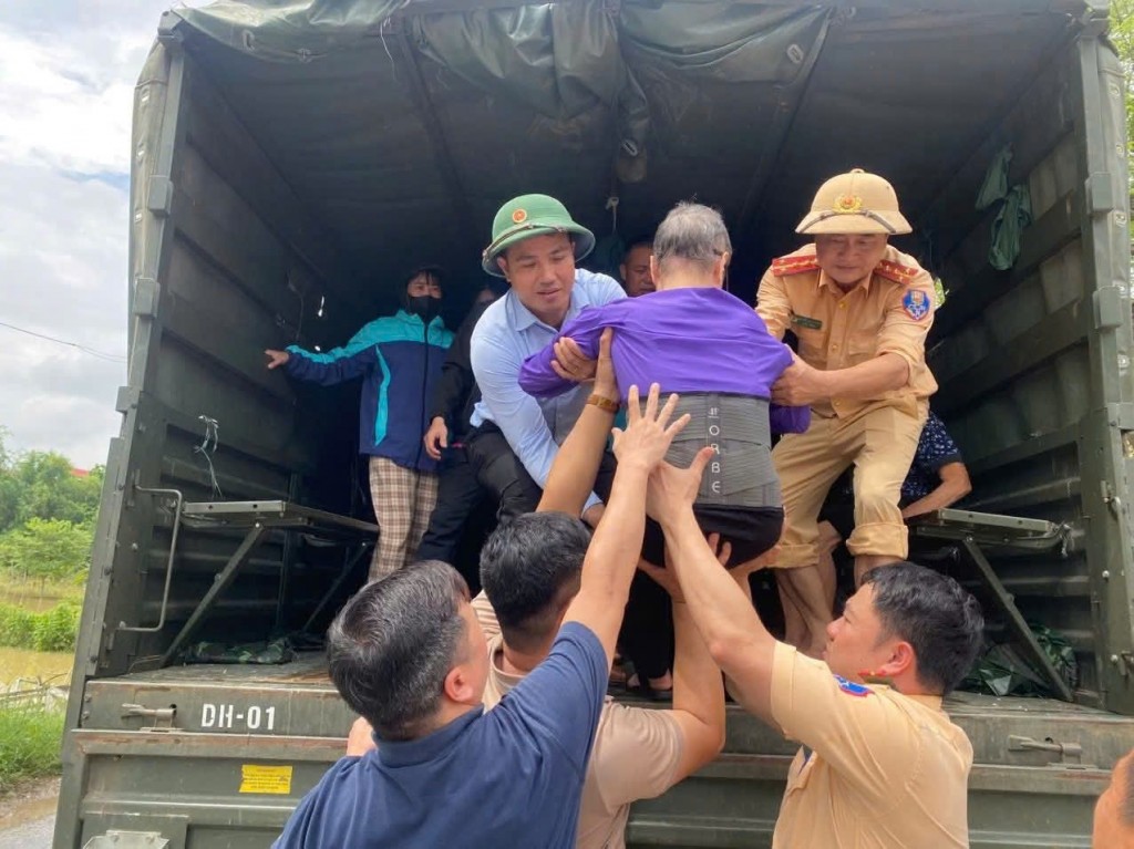 Lực lượng công an thành phố tăng cường hỗ trợ người dân ở khu vực ngập sâu di chuyển vào nơi tránh lũ an toàn. Ảnh: Văn hóa Trung Giã