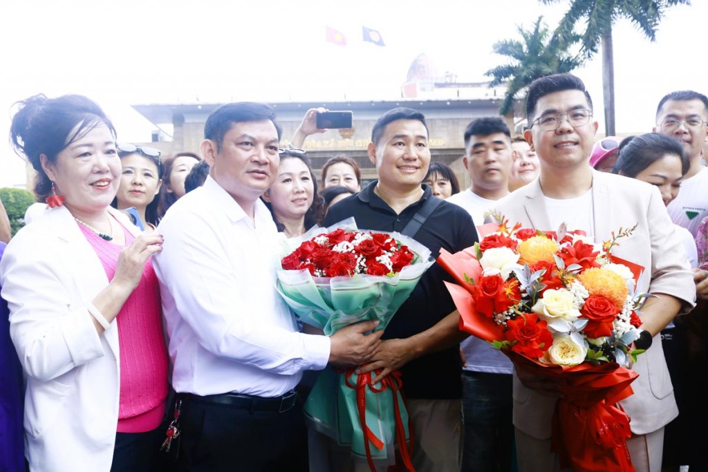 Ông Đỗ Văn Tuấn, Chủ tịch UBND phường Móng Cái 1, tỉnh Quảng Ninh đón, tặng hoa chúc mừng đoàn du khách Trung Quốc.