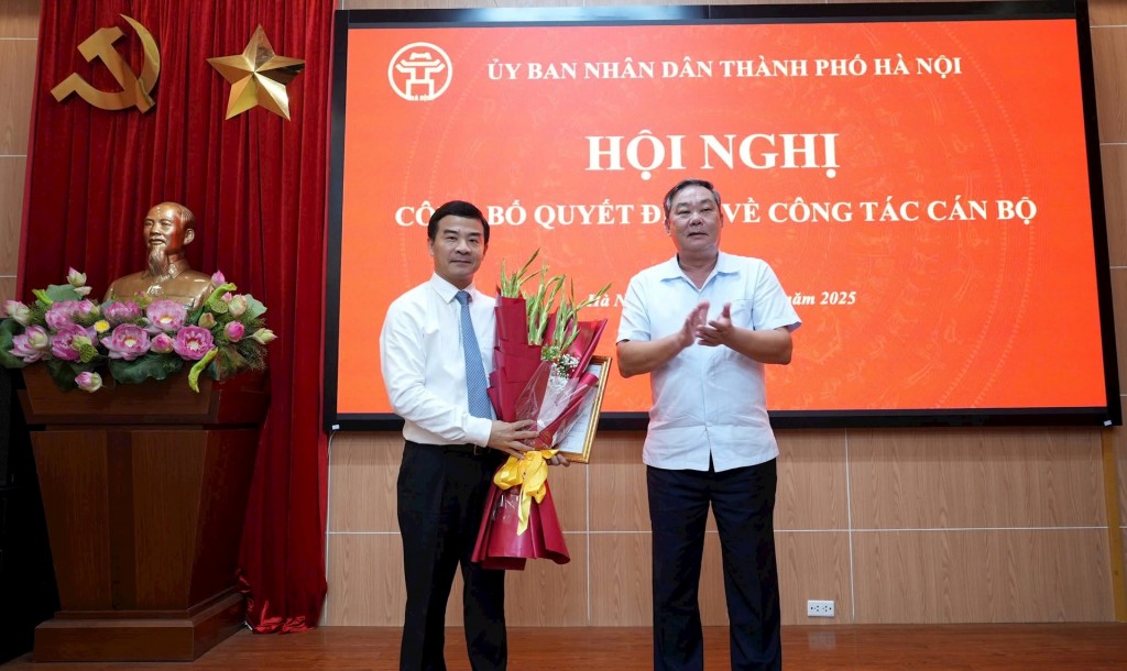 Phó Chủ tịch Thường trực UBND thành phố Hà Nội Lê Hồng Sơn trao quyết định, tặng hoa chúc mừng đồng chí Nguyễn Xuân Lưỡng. Ảnh: SNV