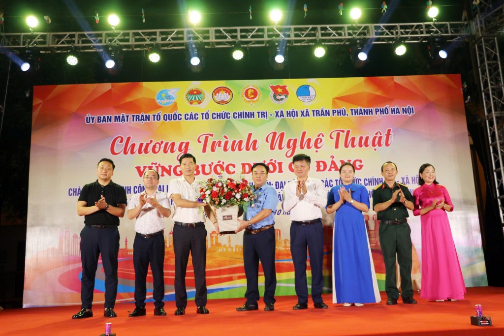 Lãnh đạo xã dự và tặng hoa chúc mừng.