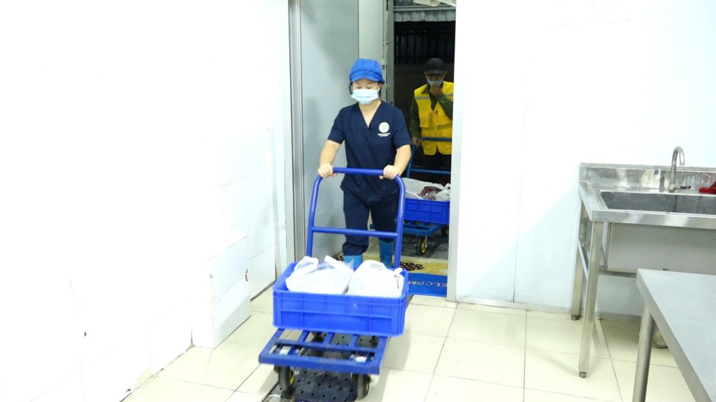Nhân viên bếp ăn vận chuyển thực phẩm vào khu vực sơ chế, nấu ăn