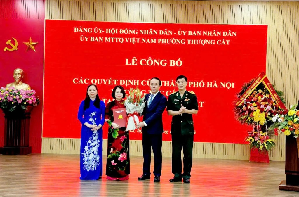 Bí thư Đảng ủy, Chủ tịch HĐND phường Thượng Cát Lưu Ngọc Hà trao Quyết định của Ủy ban MTTQ TP về công nhận Ủy viên Ủy ban và các chức danh trong Ban Thường trực Ủy ban MTTQ Việt Nam phường và tặng hoa chúc mừng.