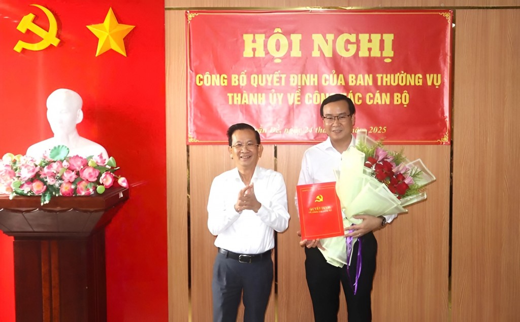 Nguyễn Thiện Nhơn, Ủy viên Ban Thường vụ, Trưởng Ban Tổ chức Thành ủy Cần Thơ trao quyết định và tặng hoa chúc mừng ông Nguyễn Quốc Trung. Ảnh: Văn Sông