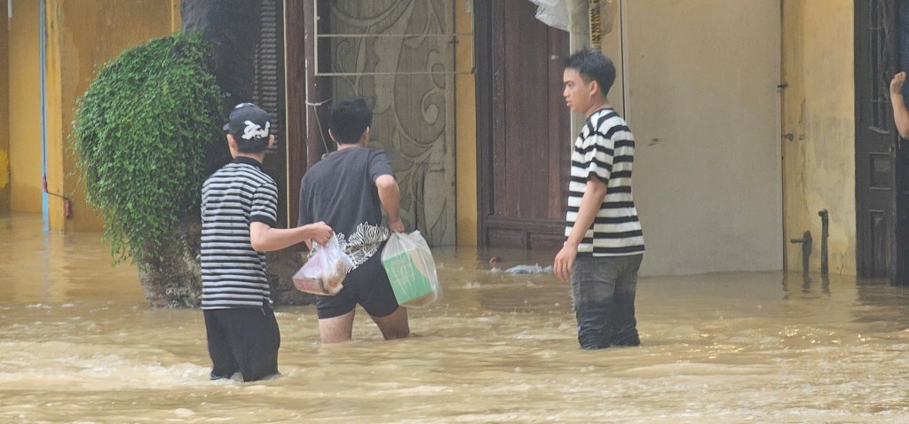 Công an hỗ trợ người dân di chuyển qua vùng lũ Hội An