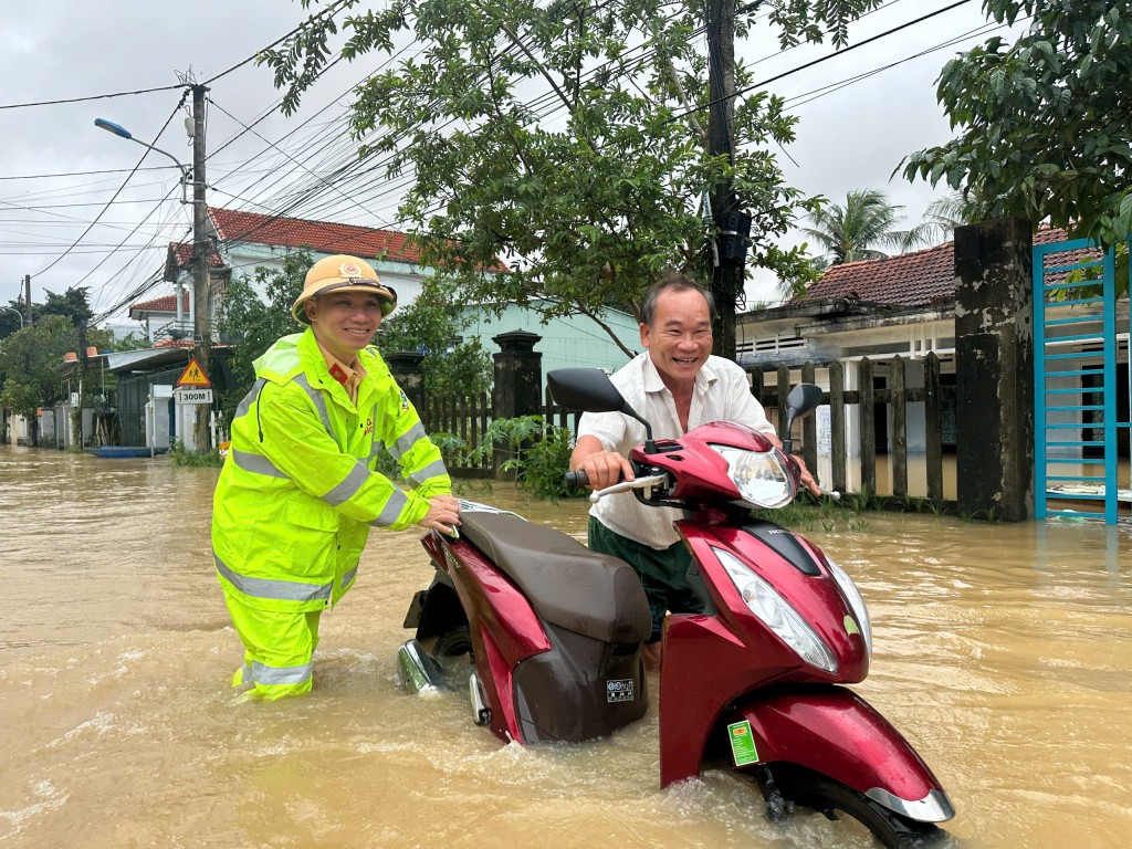Lực lượng Cảnh sát Giao thông hỗ trợ người dân di chuyển qua vùng ngập (Ảnh Đ.Minh)