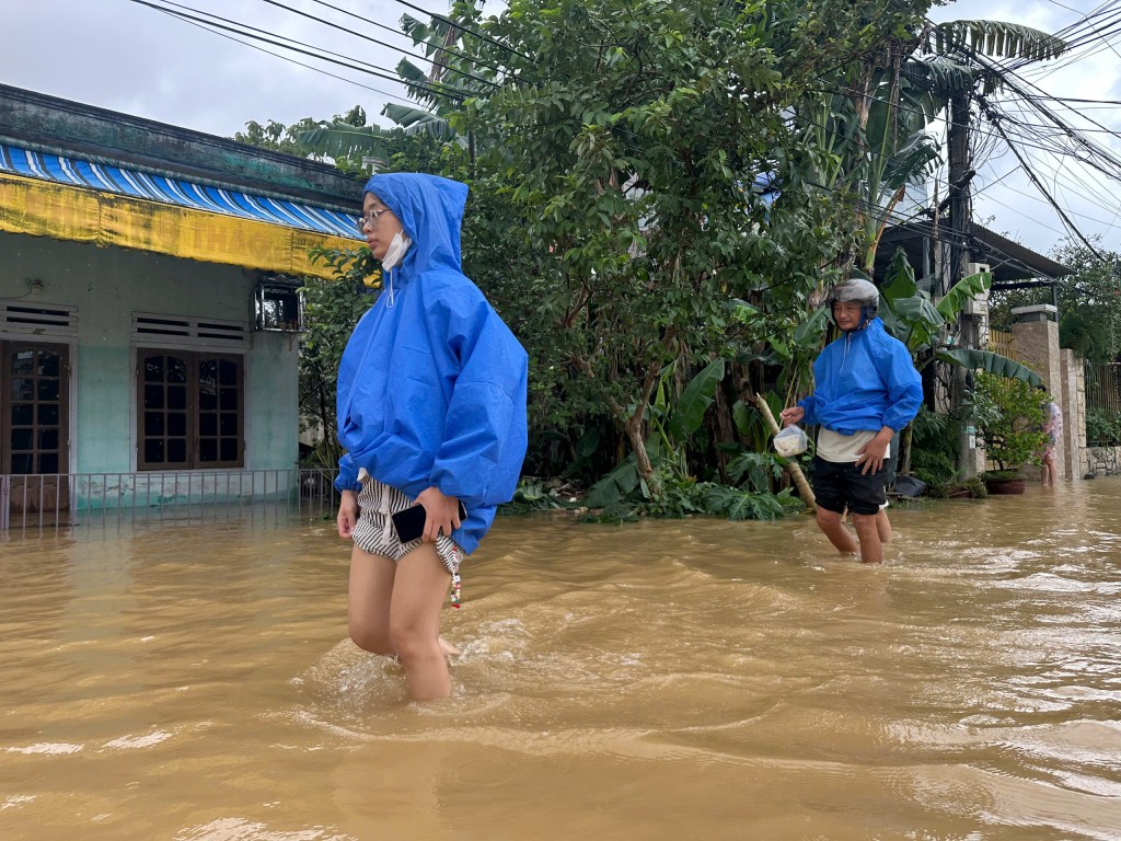 Người dân lội bì bõm trong nước lũ (Ảnh Đ.Minh)
