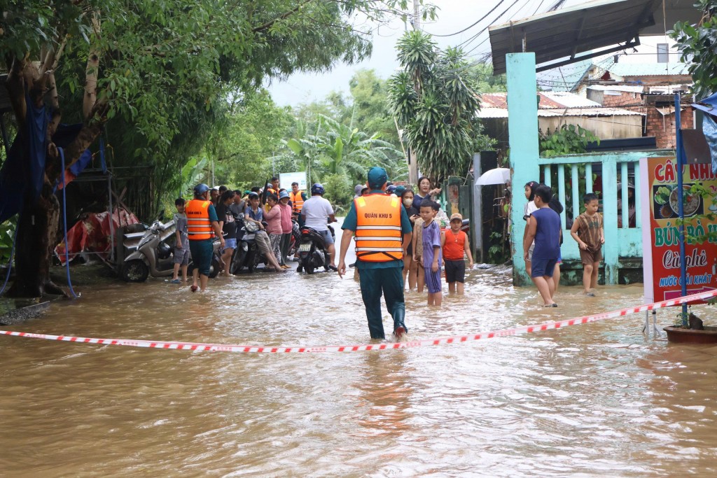 Lực lượng chức năng dựng biển cảnh báo, túc trực tại nhiều tuyến đường bị ngập sâu (Ảnh Đ.Minh)