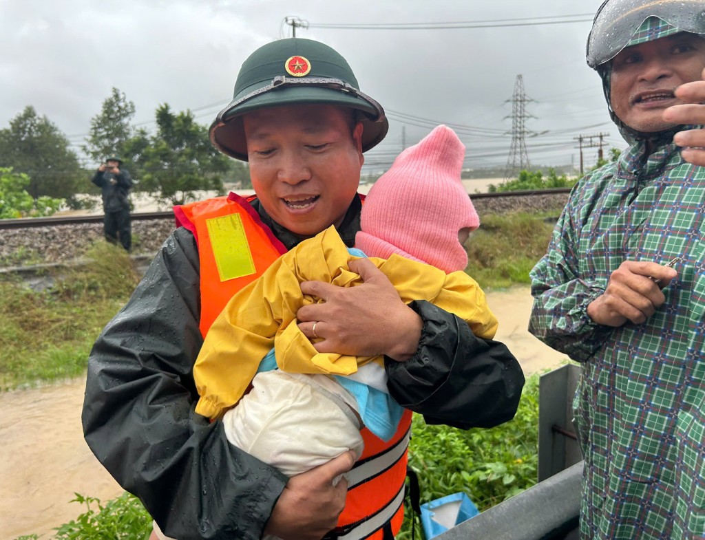 Mặc trời mưa lớn, các chiến sĩ công an, bộ đội vẫn kiên trì bám địa bàn, dầm mình trong nước để hỗ trợ người già yếu, trẻ em (Ảnh Đ.Minh)