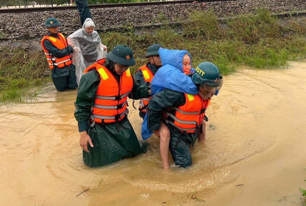 Ưu tiên trẻ nhỏ, người già yếu được lực di dời đến nơi an toàn trước khi nước tiếp tục dâng cao (Ảnh Đ.Minh)