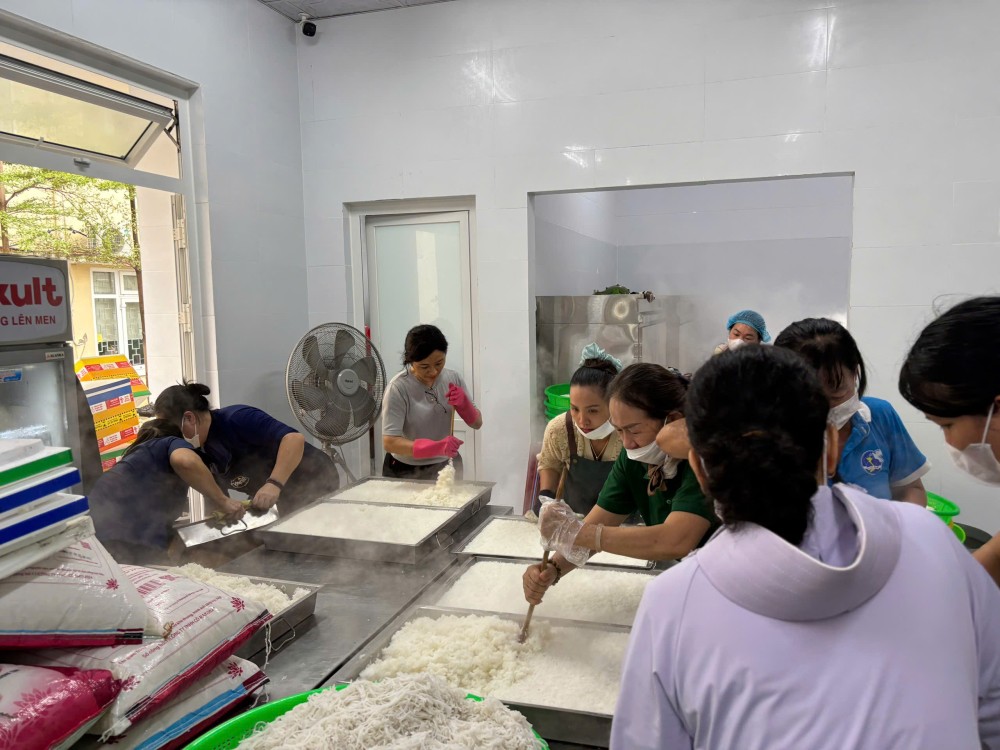 Các chị em phụ nữ tất bật sơ chế thực phẩm, chuẩn bị nguyên liệu cho bếp ăn thiện nguyện trong những ngày mưa lũ